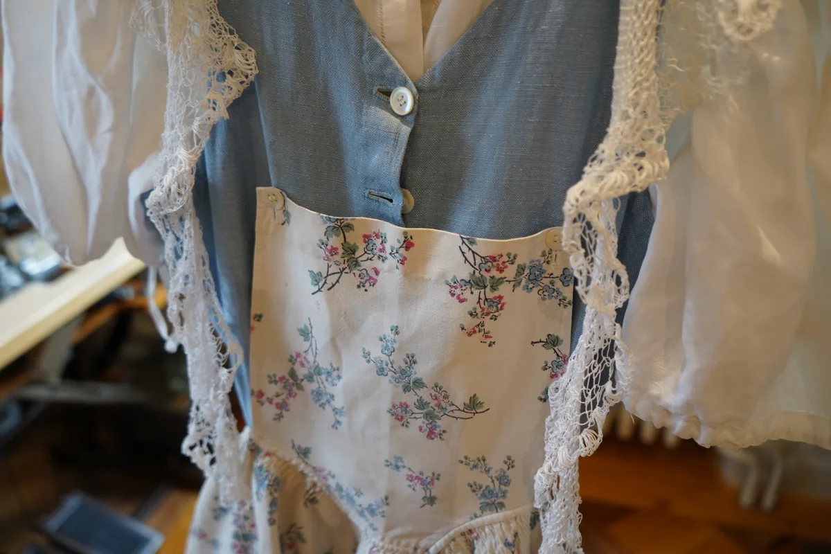 Eine hellblaue Tracht mit einer weissen Blumenschürze.